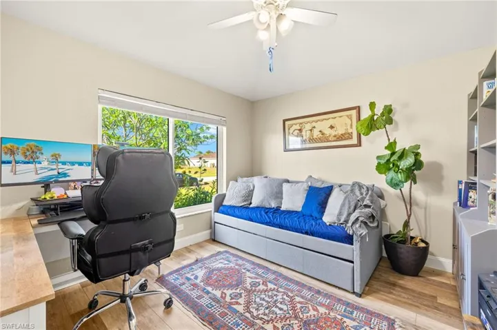 Home office featuring light wood-type flooring, a ceiling fan, and baseboards