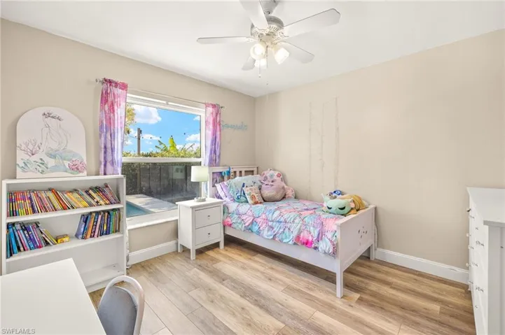 Bedroom with light wood-type flooring, baseboards, and a ceiling fan