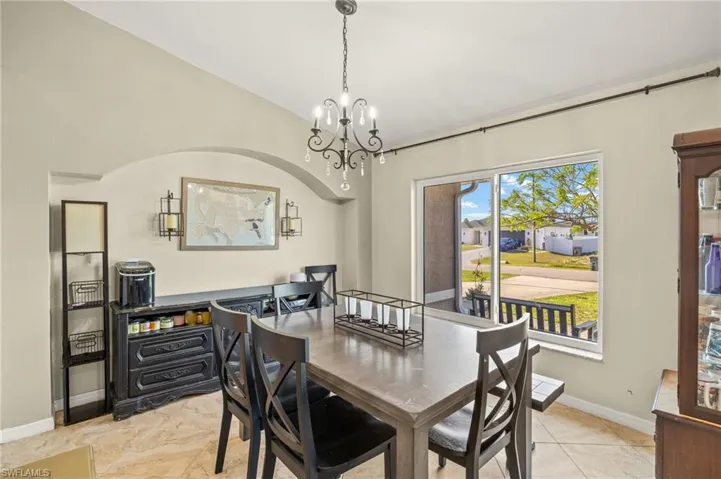 Dining space with a chandelier, baseboards, and lofted ceiling