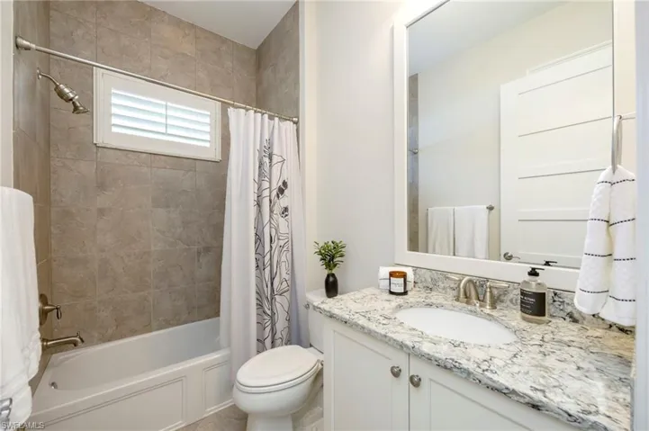 Full bathroom with a linen closet and window