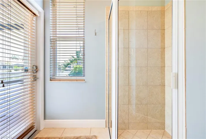 Bathroom featuring a stall shower, tile patterned flooring, and baseboards