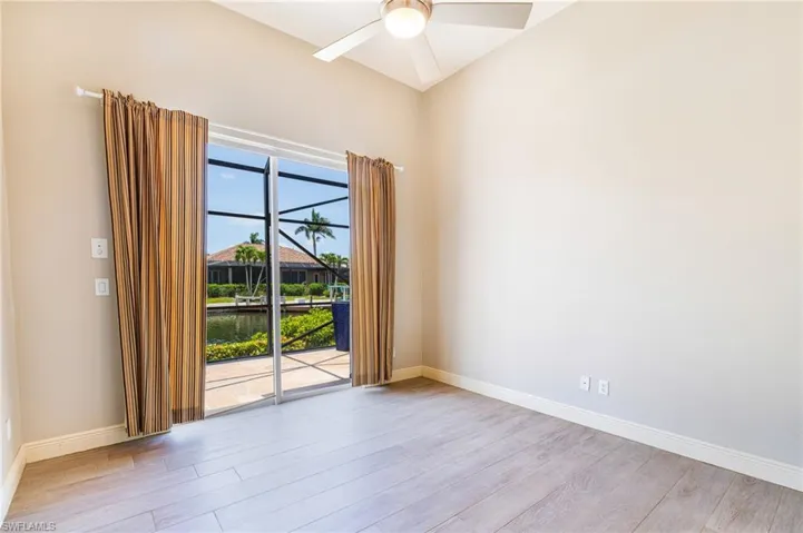 Unfurnished room with wood finished floors, a ceiling fan, and baseboards