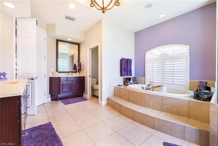 Full bath featuring vanity, a bath, toilet, tile patterned flooring, and recessed lighting