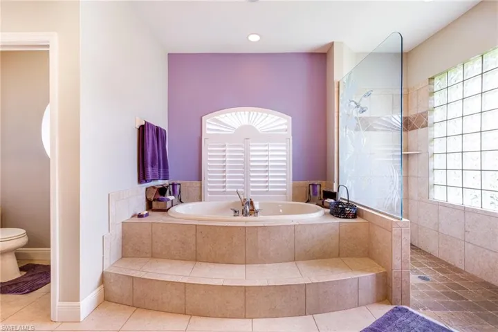 Full bathroom with healthy amount of natural light, a bath, toilet, and a walk in shower