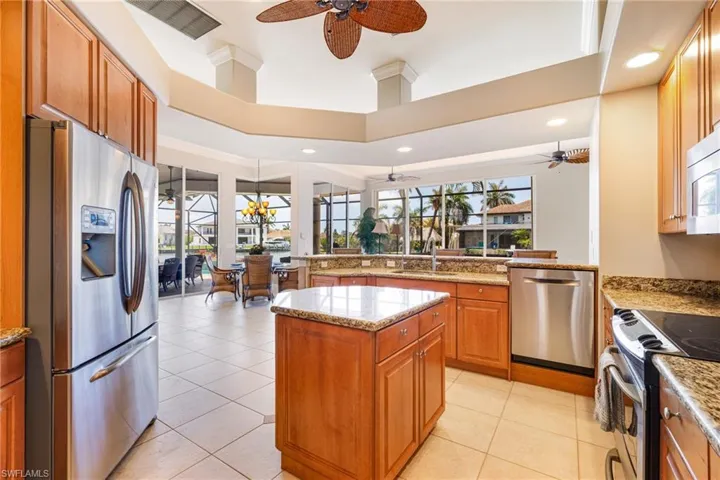 Kitchen with stainless steel appliances, ceiling fan, a sink, brown cabinets, and recessed lighting