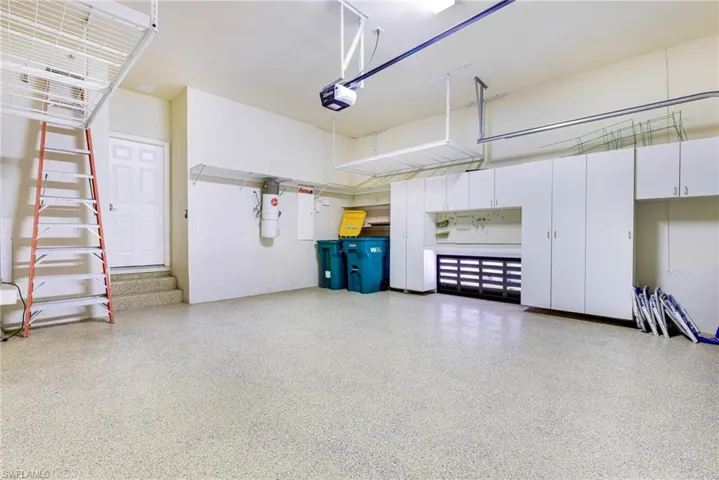 Garage with a garage door opener and a central vacuum unit