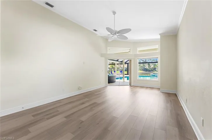 Unfurnished room featuring wood-type flooring, ceiling fan, and crown molding