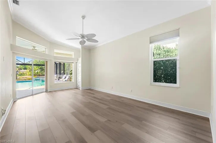 Unfurnished room with wood-type flooring, ornamental molding, plenty of natural light, and ceiling fan