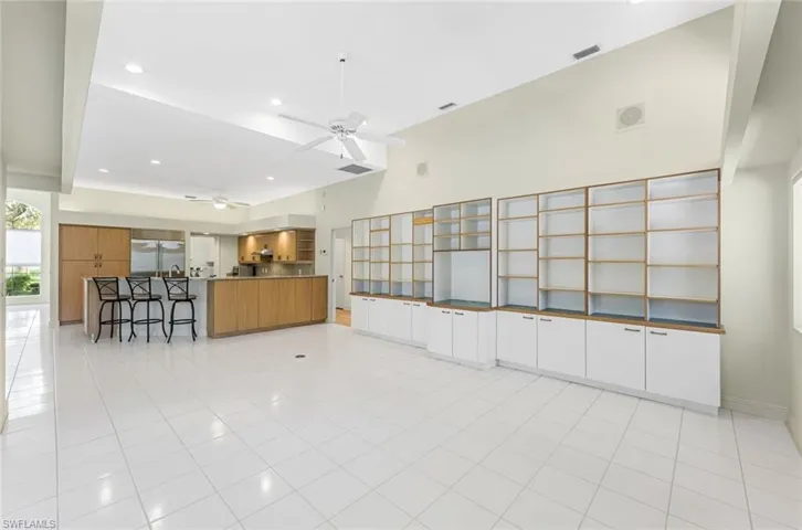 Unfurnished living room with ceiling fan and light tile floors