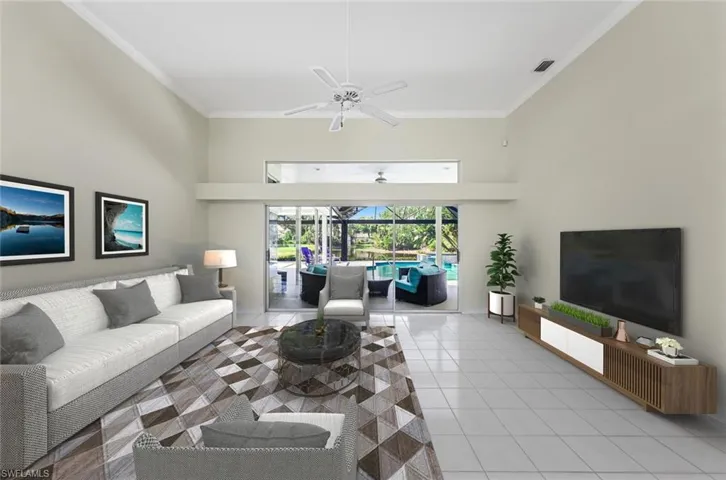 Virtually furnished.  Living room featuring a high ceiling, ceiling fan, and light tile floors