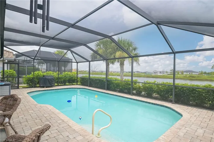 View of swimming pool featuring a lanai and a patio area