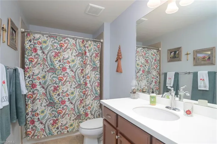 Bathroom featuring tile patterned flooring, toilet, and vanity