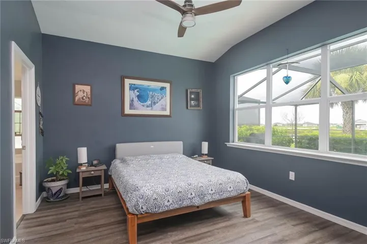 Bedroom with ceiling fan, lofted ceiling, and hardwood / wood-style floors