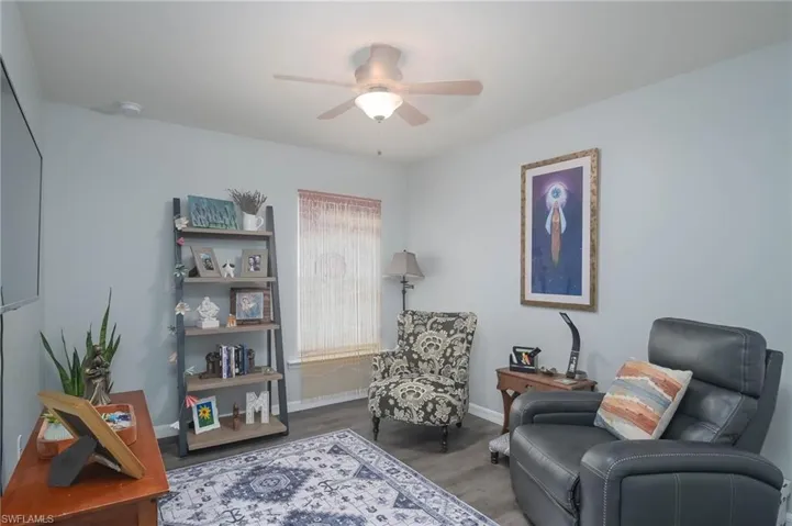 Sitting room with wood-type flooring and ceiling fan