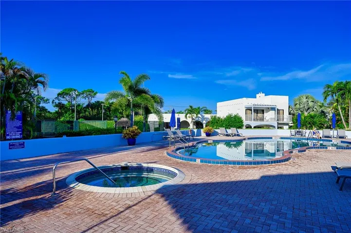 Community pool featuring a hot tub and a patio