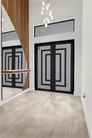 Front entrance with custom impact glass door, mirrored accent wall and drop shelf.