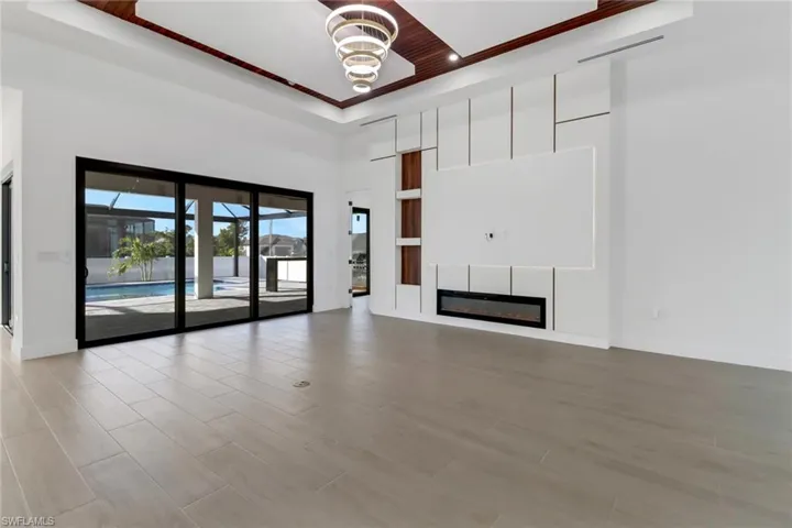 Great room with electric fireplace, entertainment wall and custom wood accent ceiling