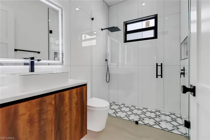 Guest bath w/ custom tile work and frameless shower door.