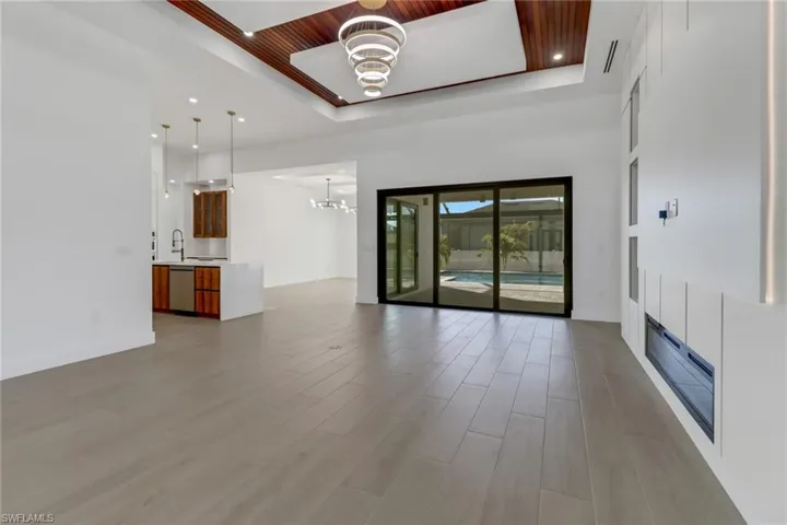 Great room with electric fireplace, entertainment wall and custom wood accent ceiling