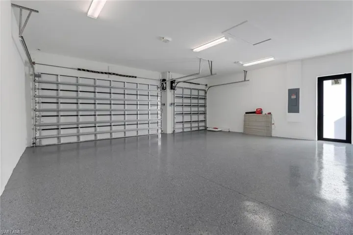 3 car garage w/ epoxy floor and frosted impact door for natural light.