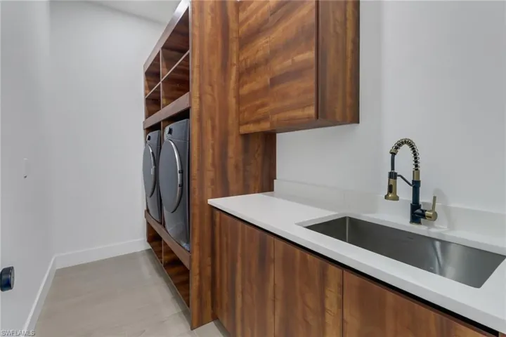 laundry room with custom cabinets and utility sink.