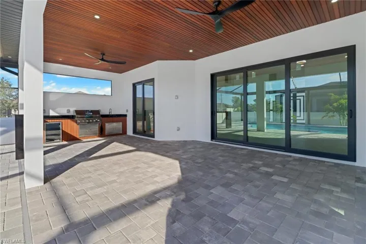 Large under truss lanai for entertaining and Summer kitchen with stainless appliances and granite bar.