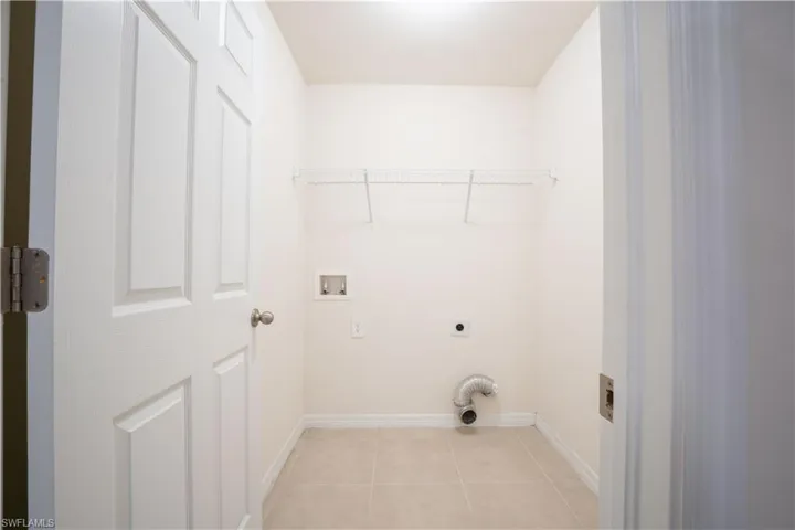 Washroom with washer hookup, electric dryer hookup, and light tile patterned floors