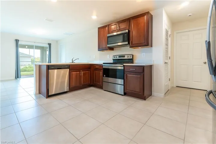 Kitchen featuring stainless steel appliances, sink, light tile