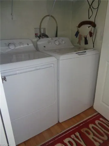 Laundry area with light wood-style flooring and washer and clothes dryer