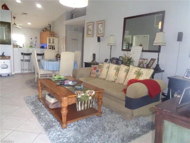 Living area featuring light tile patterned floors, washer / dryer, recessed lighting, and a ceiling fan