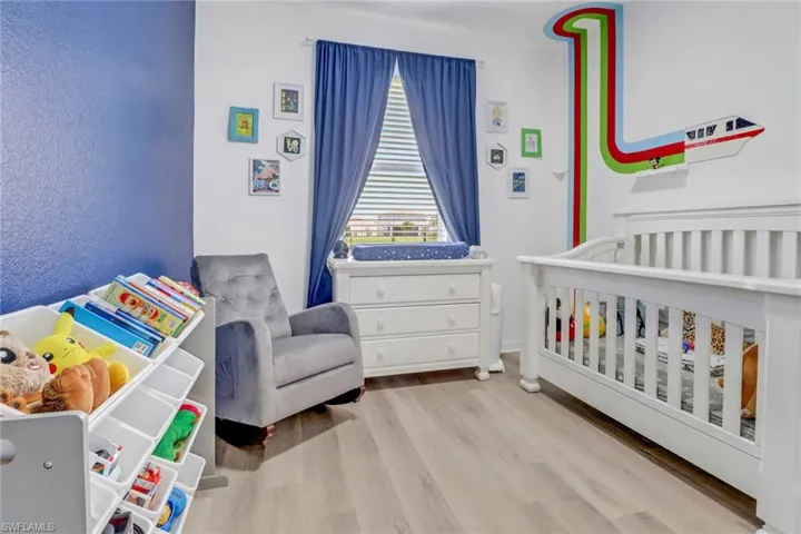 Bedroom featuring a crib and wood finished floors