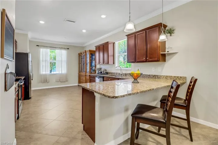 Kitchen with visible vents, a breakfast bar, ornamental molding, appliances with stainless steel finishes, and a sink