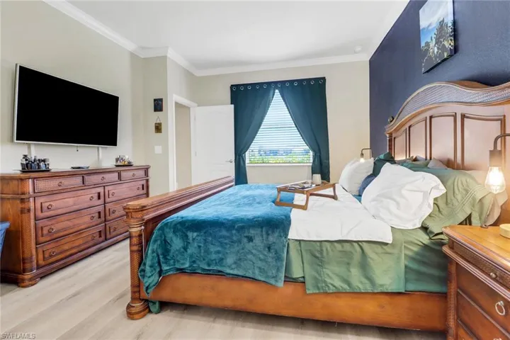 Bedroom with light wood-style flooring and crown molding