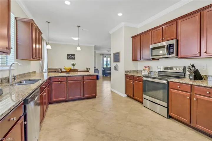Kitchen featuring a sink, appliances with stainless steel finishes, and crown molding