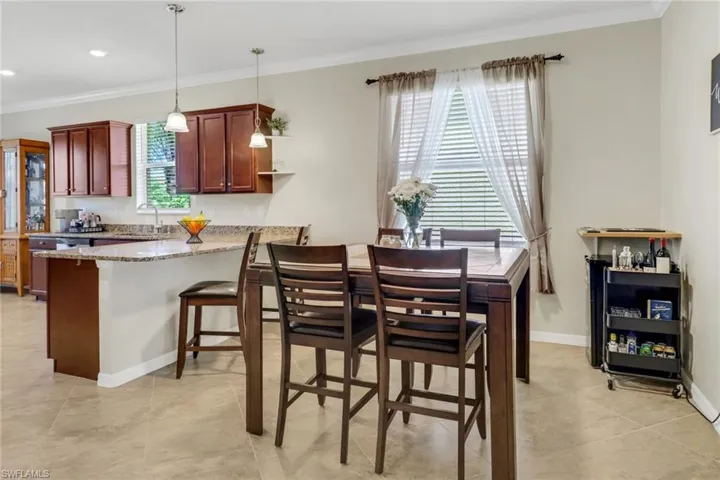 Dining area featuring light tile patterned floors, crown molding, baseboards, and recessed lighting