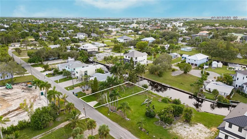 Aerial view of property and surrounding area featuring nearby suburban area