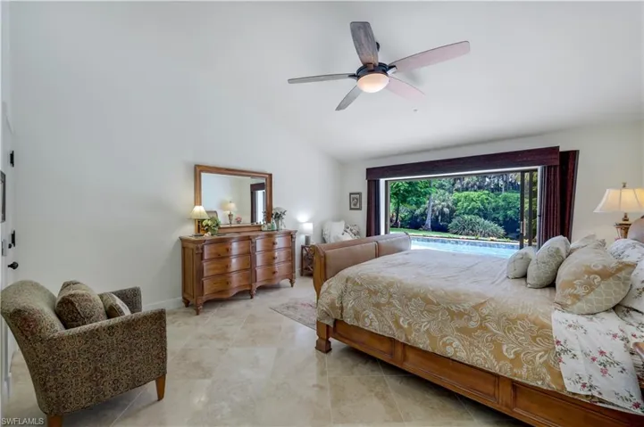 Tiled bedroom featuring high vaulted ceiling and ceiling fan