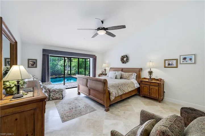 Bedroom with lofted ceiling, access to exterior, light tile patterned floors, and ceiling fan