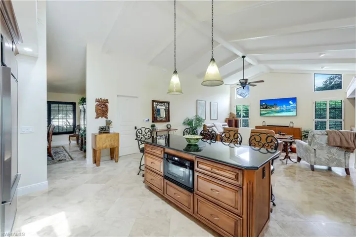 Kitchen with beamed ceiling, a kitchen breakfast bar, and a kitchen island