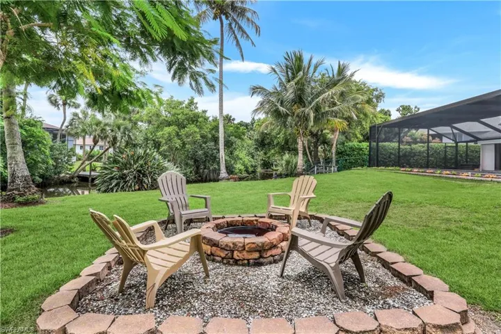 View of patio featuring a fire pit and glass enclosure