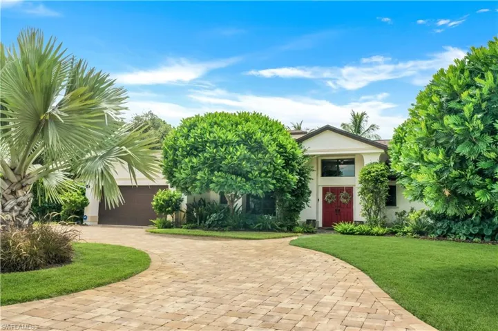 View of front facade featuring a garage and a front yard
