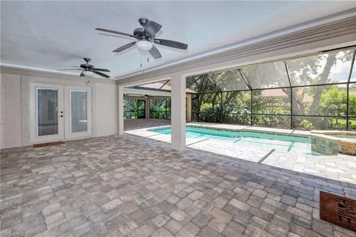 View of pool with ceiling fan, a lanai, a patio, and french doors