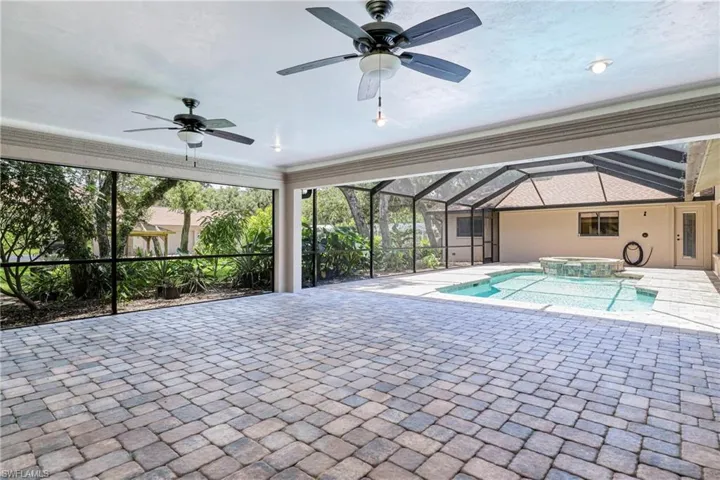View of pool with ceiling fan, a patio, and a lanai