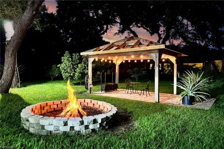 View of home's community with a pergola, a lawn, a patio, and a fire pit