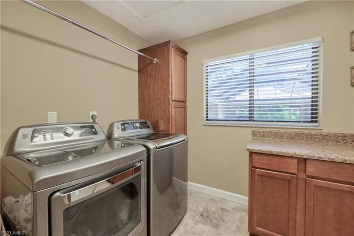 Laundry with built in cabinetry and ironing center