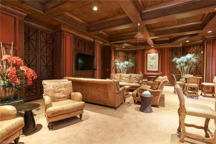 Carpeted living room featuring wooden ceiling, wooden walls, ornamental molding, beam ceiling, and coffered ceiling