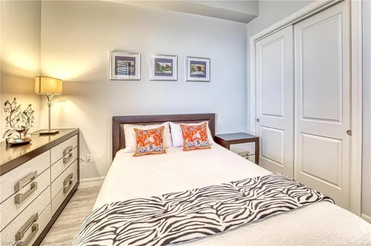 Bedroom with light hardwood / wood-style floors and a closet