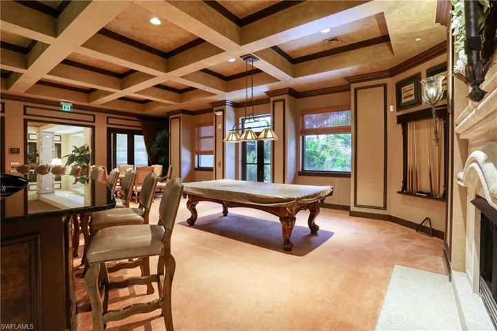 Rec room with beamed ceiling, light colored carpet, crown molding, billiards, and coffered ceiling