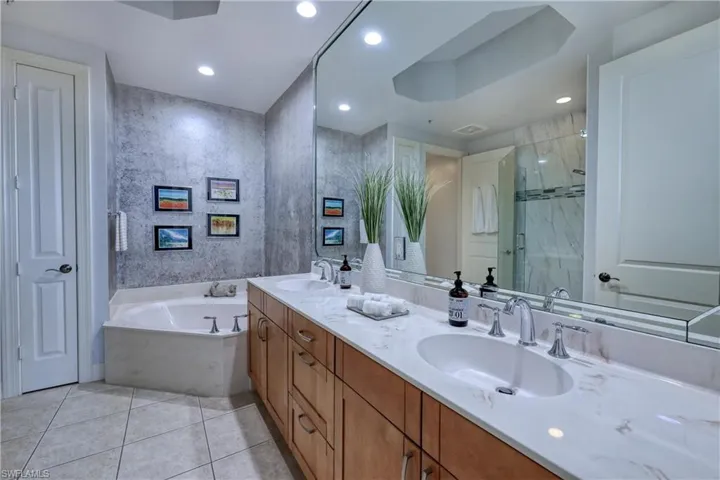 Bathroom featuring shower with separate bathtub, tile patterned floors, and double sink vanity