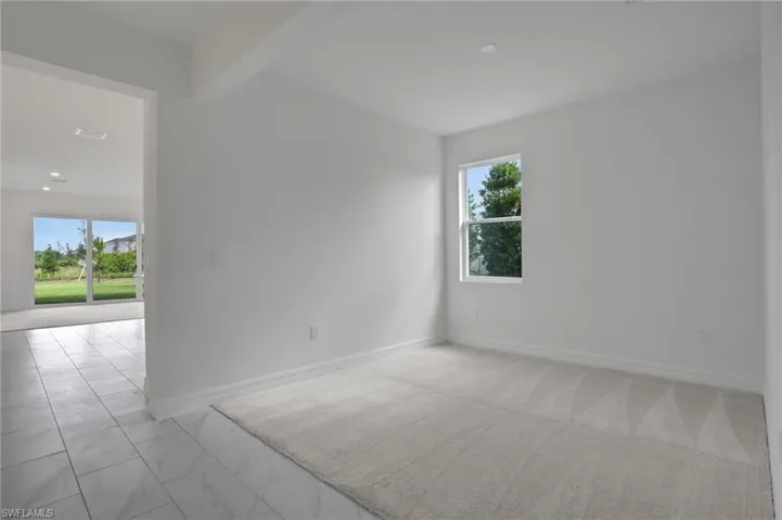 Empty room featuring baseboards and beamed ceiling